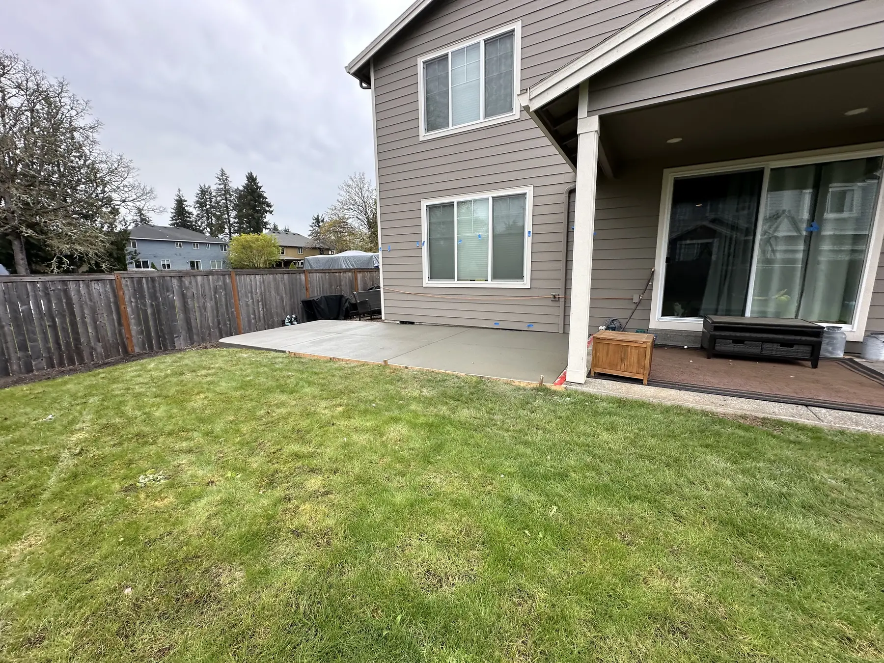 Concrete patio beside a home and lawn, from Maximus Construction Group’s project gallery